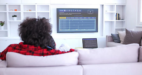 Image showing Young couple on the sofa watching television