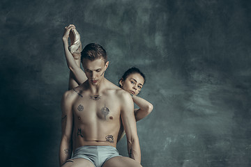 Image showing The young modern ballet dancers posing on gray studio background