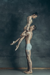 Image showing The young modern ballet dancers posing on gray studio background