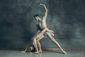 Image showing The young modern ballet dancers posing on gray studio background