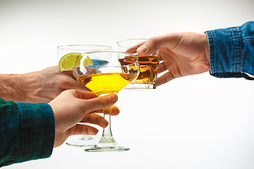 Image showing The male and female hands with exotic cocktails