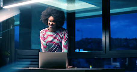 Image showing black businesswoman using a laptop in night startup office