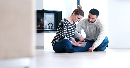 Image showing Young Couple using digital tablet on the floor