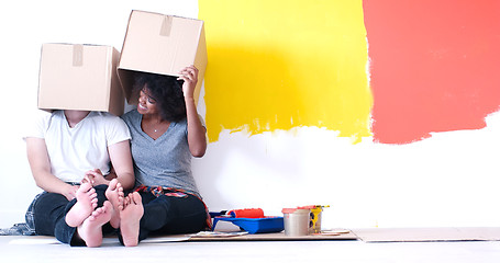 Image showing young multiethnic couple playing with cardboard boxes