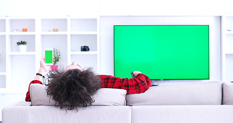 Image showing Young couple on the sofa watching television