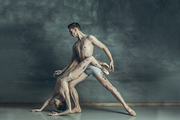 Image showing The young modern ballet dancers posing on gray studio background