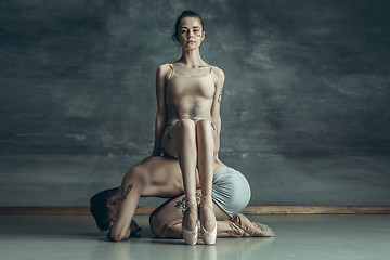 Image showing The young modern ballet dancers posing on gray studio background