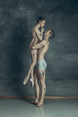 Image showing The young modern ballet dancers posing on gray studio background