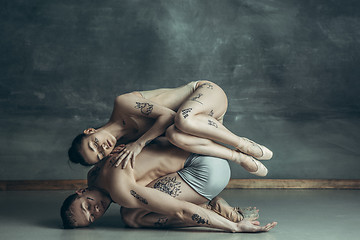 Image showing The young modern ballet dancers posing on gray studio background