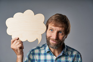 Image showing Studio portrait of smiling mature man holding speech bubble