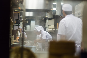 Image showing Japanese Ramen chefs prepare a bowl of traditional home made ramen noodle for customers in Kyoto, Japan.