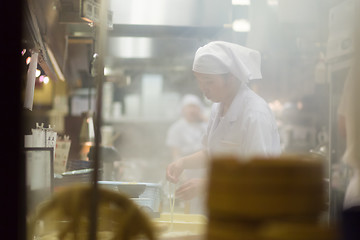 Image showing Japanese Ramen chefs prepare a bowl of traditional home made ramen noodle for customers in Kyoto, Japan.