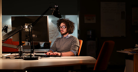 Image showing man working on computer in dark office