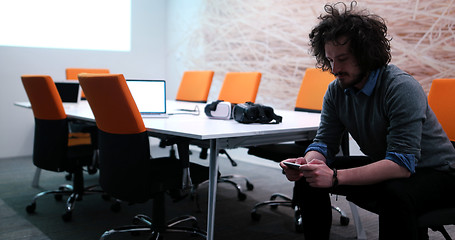 Image showing man using mobile phone in dark office