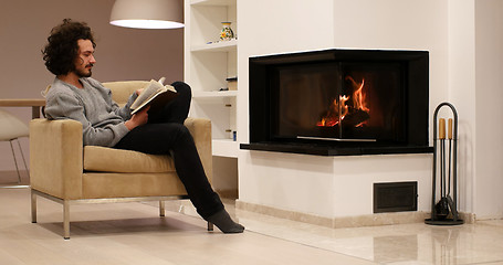 Image showing young man at home reading book