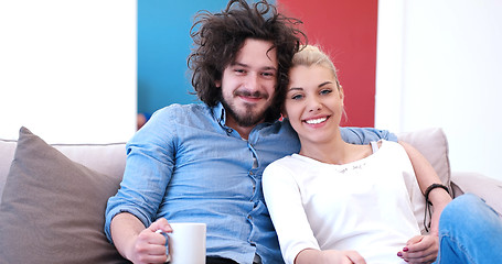 Image showing Young couple on the sofa watching television