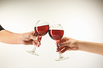 Image showing Hands with glasses of red wine, isolated on white