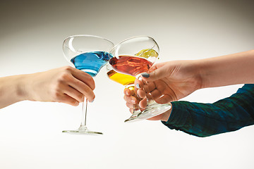 Image showing The male and female hands with exotic cocktails