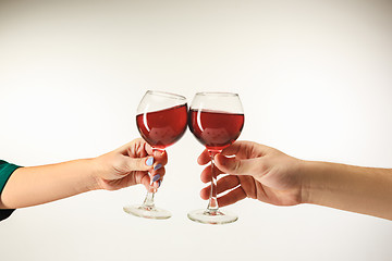 Image showing Hands with glasses of red wine, isolated on white