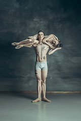 Image showing The young modern ballet dancers posing on gray studio background