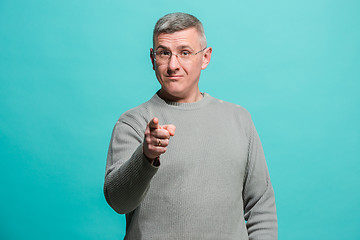 Image showing The happy business man point you and want you, half length closeup portrait on blue background.