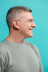 Image showing The happy business man standing and smiling against blue background.