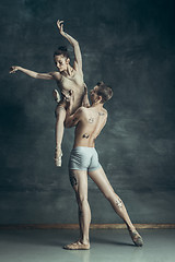 Image showing The young modern ballet dancers posing on gray studio background