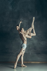 Image showing The young modern ballet dancers posing on gray studio background