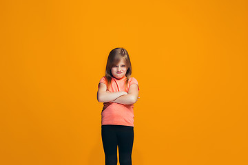 Image showing Portrait of angry teen girl on a orange studio background