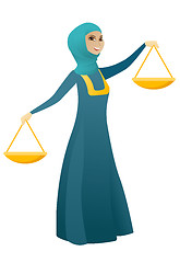 Image showing Muslim business woman holding balance scale.