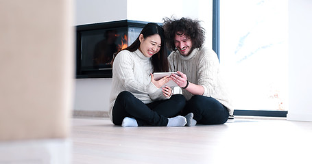 Image showing Young Couple using digital tablet on the floor