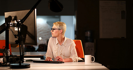 Image showing woman working on computer in dark office