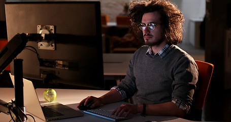 Image showing man working on computer in dark office