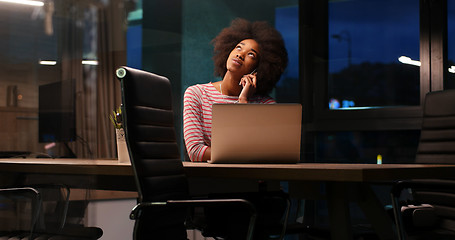 Image showing black businesswoman using a laptop in night startup office