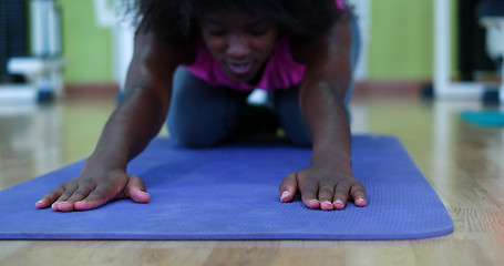 Image showing back woman in a gym stretching and warming up