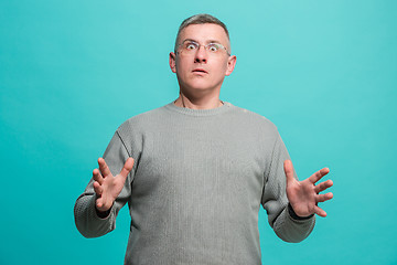 Image showing The young attractive man looking suprised isolated on blue