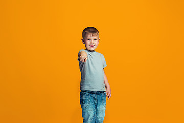 Image showing The happy teen boy pointing to you, half length closeup portrait on orange background.