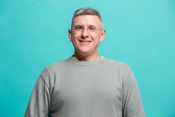 Image showing The happy business man standing and smiling against blue background.