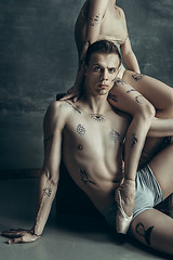 Image showing The young modern ballet dancers posing on gray studio background