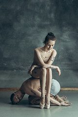 Image showing The young modern ballet dancers posing on gray studio background