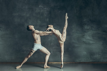 Image showing The young modern ballet dancers posing on gray studio background