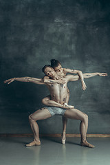 Image showing The young modern ballet dancers posing on gray studio background