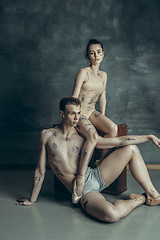 Image showing The young modern ballet dancers posing on gray studio background