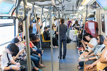 Image showing Passenegers using their mobile phone devices while commuting by city metro in Bangkok, Thailand