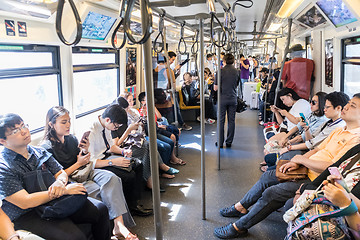 Image showing Passenegers using their mobile phone devices while commuting by city metro in Bangkok, Thailand