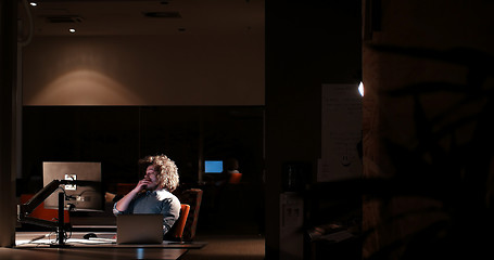 Image showing man working on computer in dark office