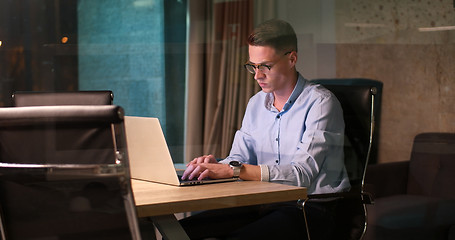 Image showing man working on laptop in dark office