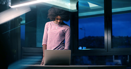 Image showing black businesswoman using a laptop in night startup office