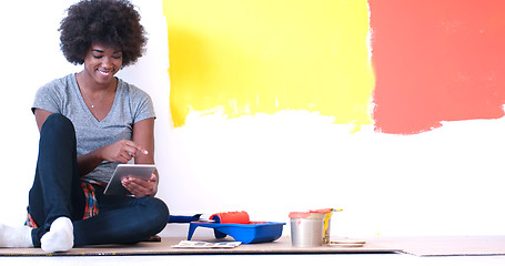 Image showing black female painter sitting on floor