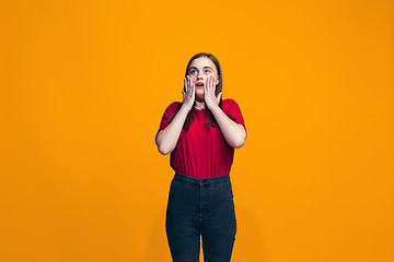 Image showing Beautiful teen girl looking suprised isolated on orange